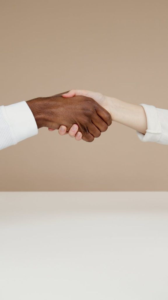 man-person-hands-love-6786946 Close-up of a diverse handshake symbolizing unity and cooperation on a neutral background.